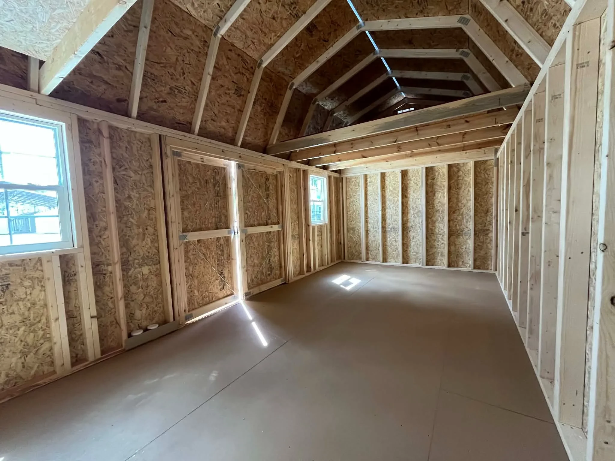 Interior of a 10x20 side lofted barn showing the windows, doors and loft area