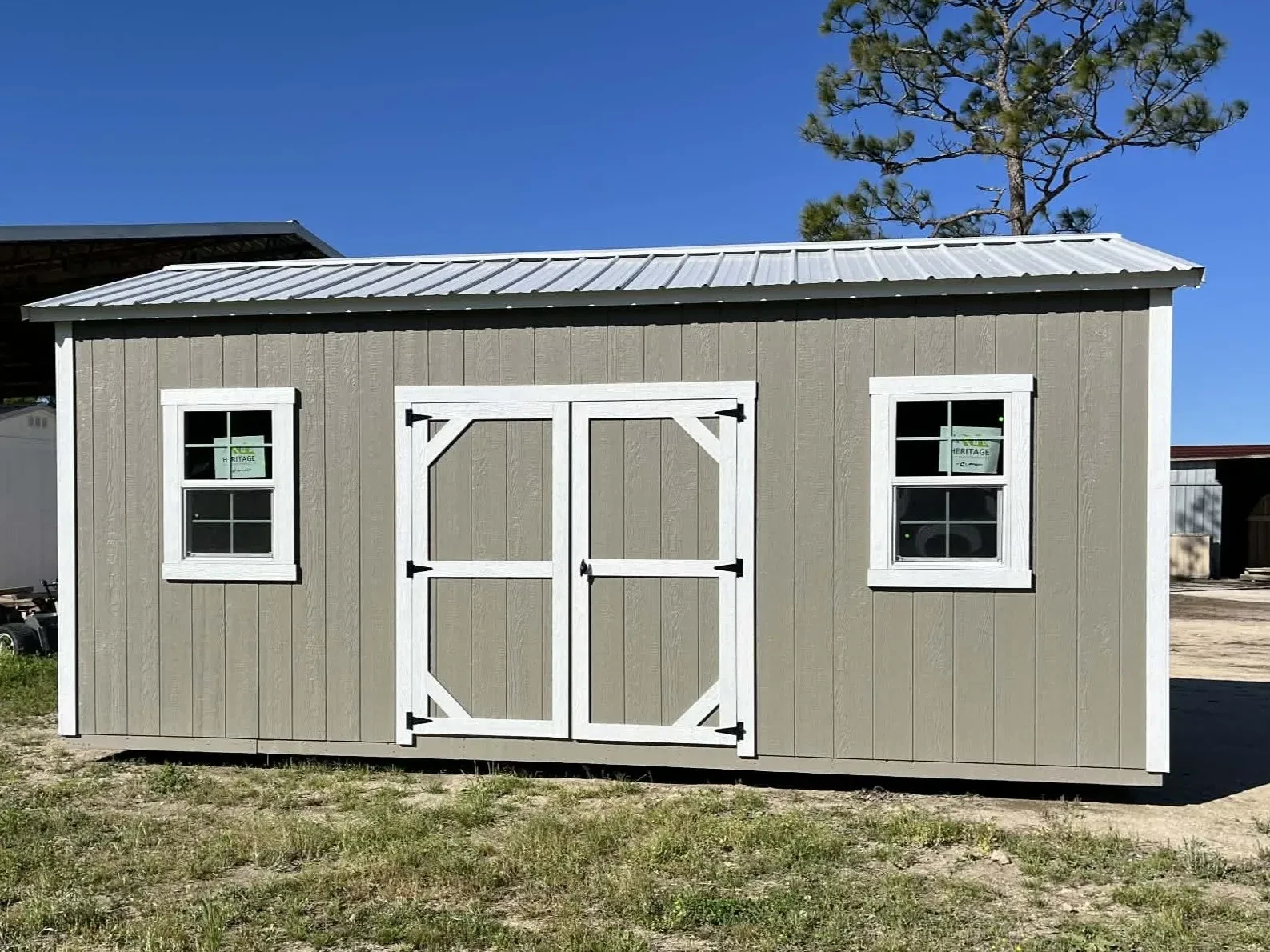 Exterior view of a clay color 10x20 side garden shed showing the windows and door