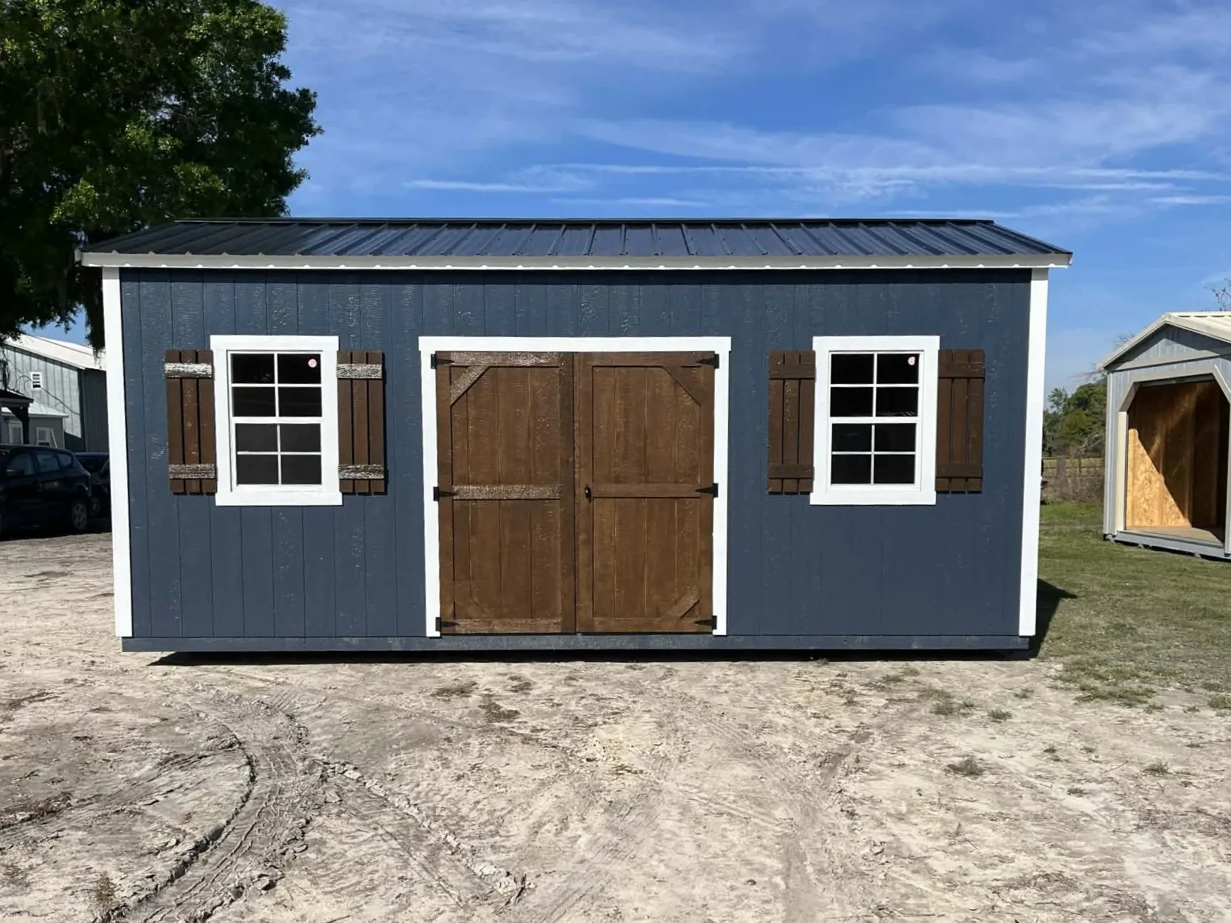 Exterior front view of a 10x20 side garden shed showing wood doors and windows