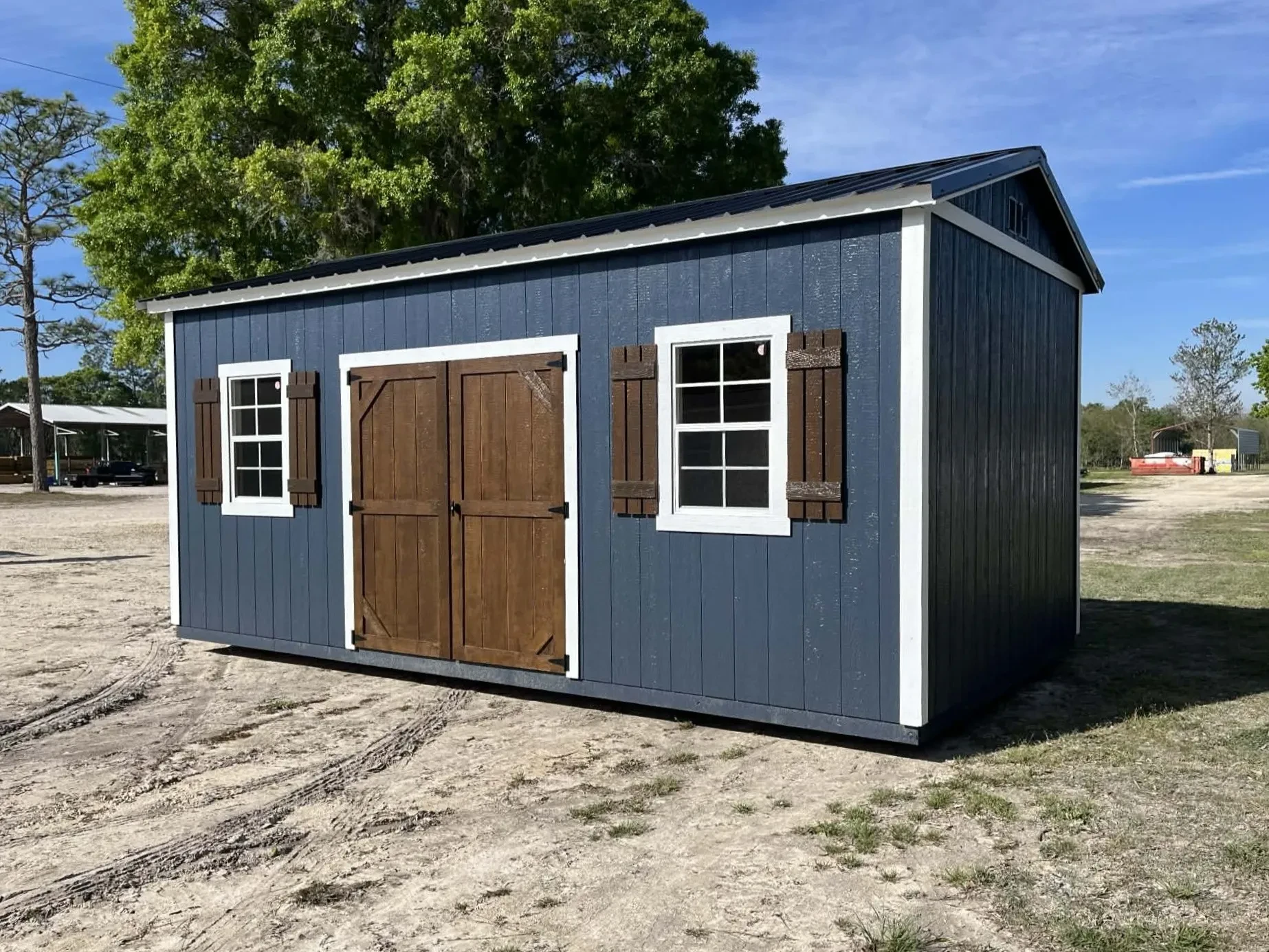 Exterior front side view of a 10x20 side garden shed showing wood doors and windows