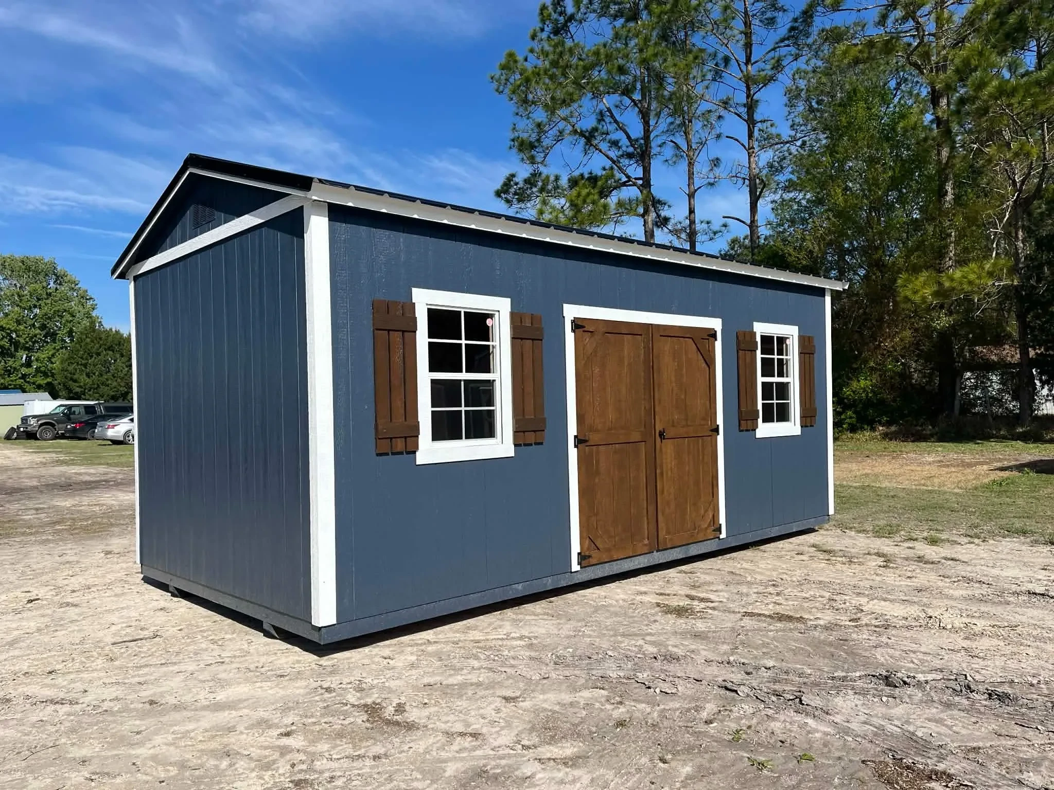 Exterior front side view of a 10x20 side garden shed showing wood doors and windows