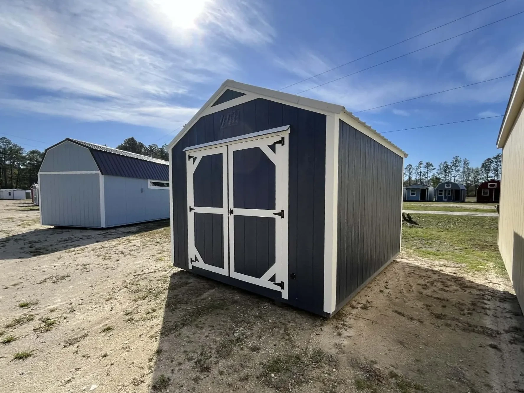 Exterior side front view of a 10x12 dark blue garden shed economy showing wood entry doors