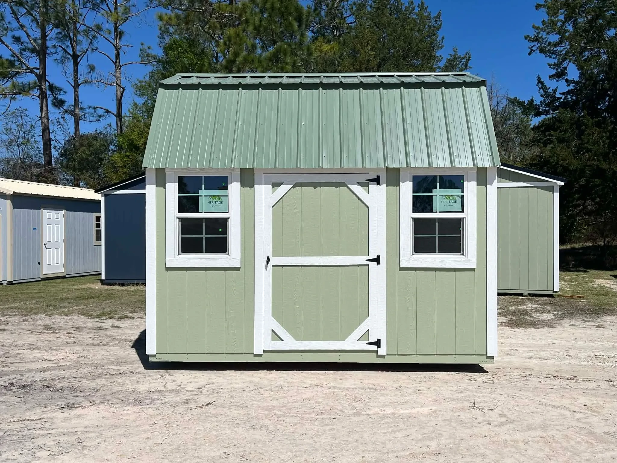 Exterior view of a green 8x12 side lofted barn showing the door and windows