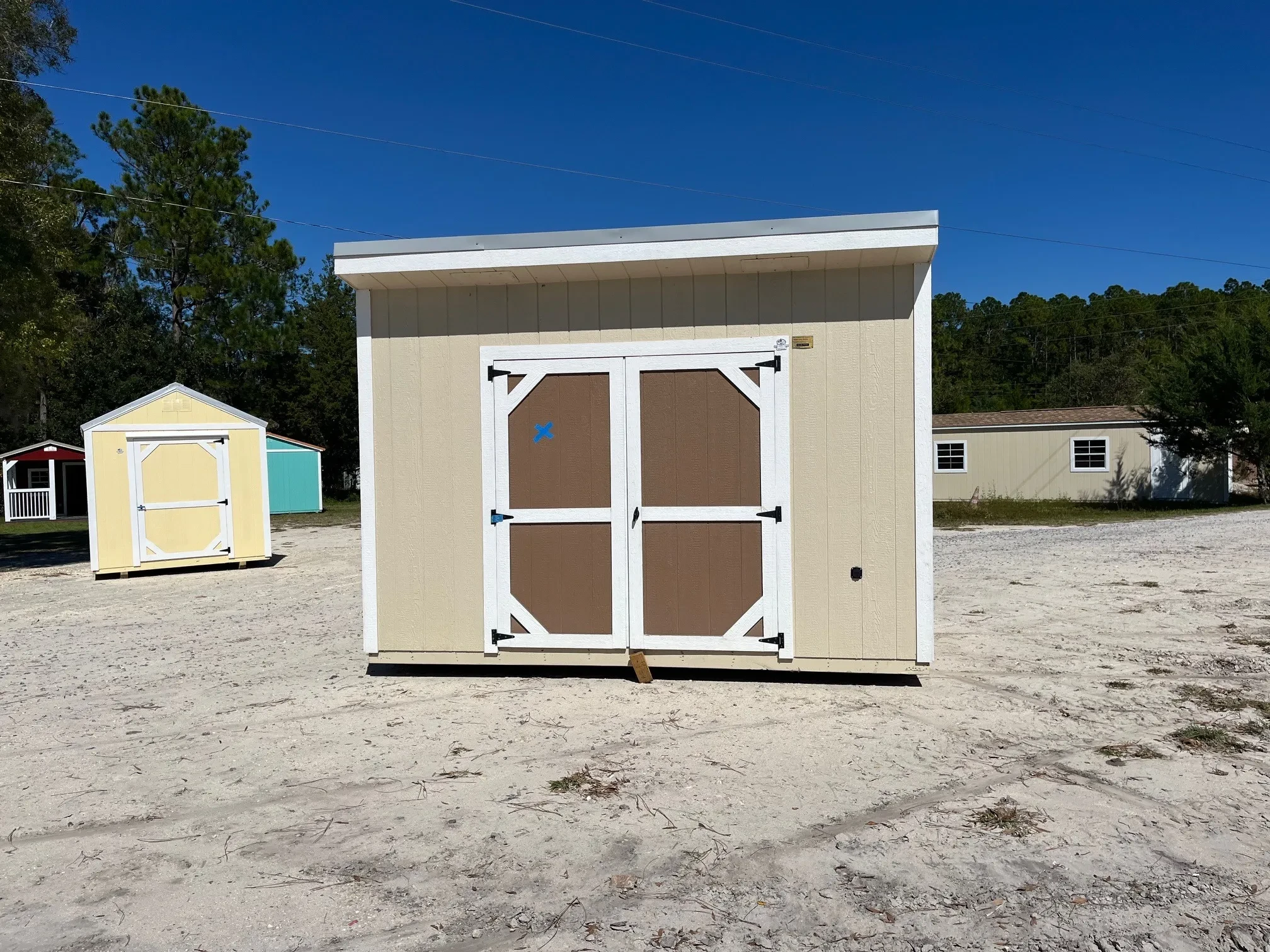 Exterior front view of an almond 8x12 urban with a brown door