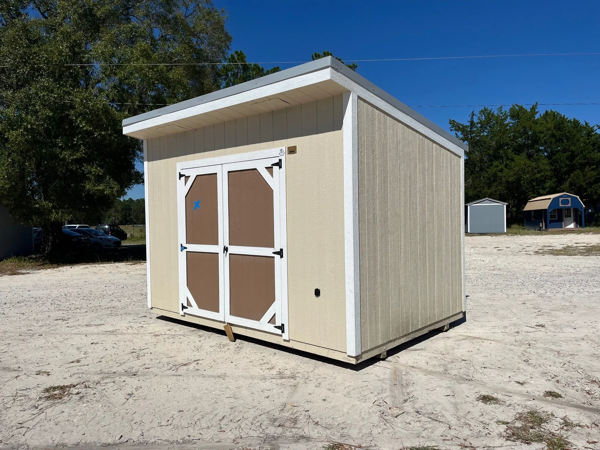 Exterior front side view of an almond 8x12 urban with a brown door