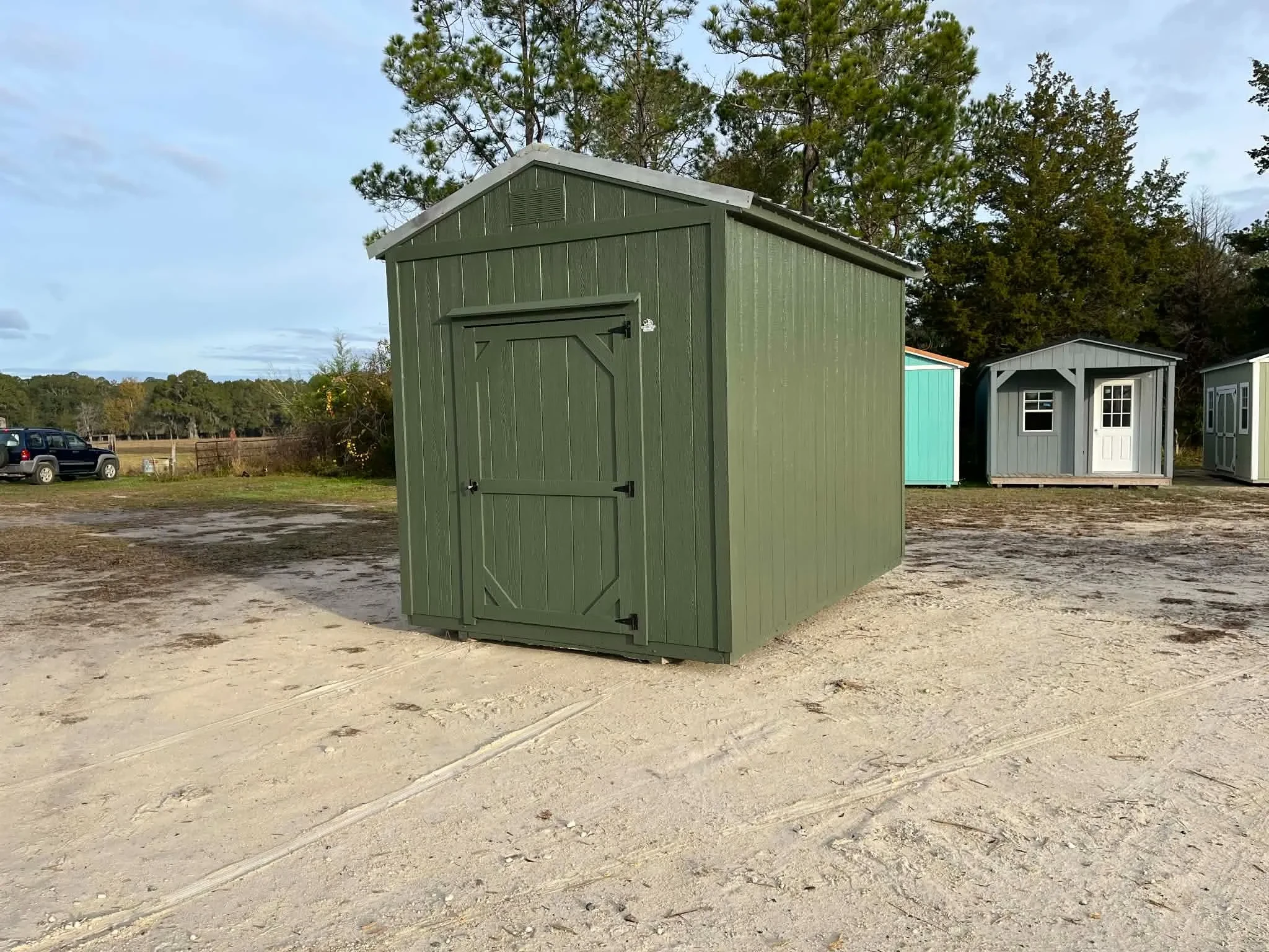 Exterior front view of a green 8x12 garden shed showing the door