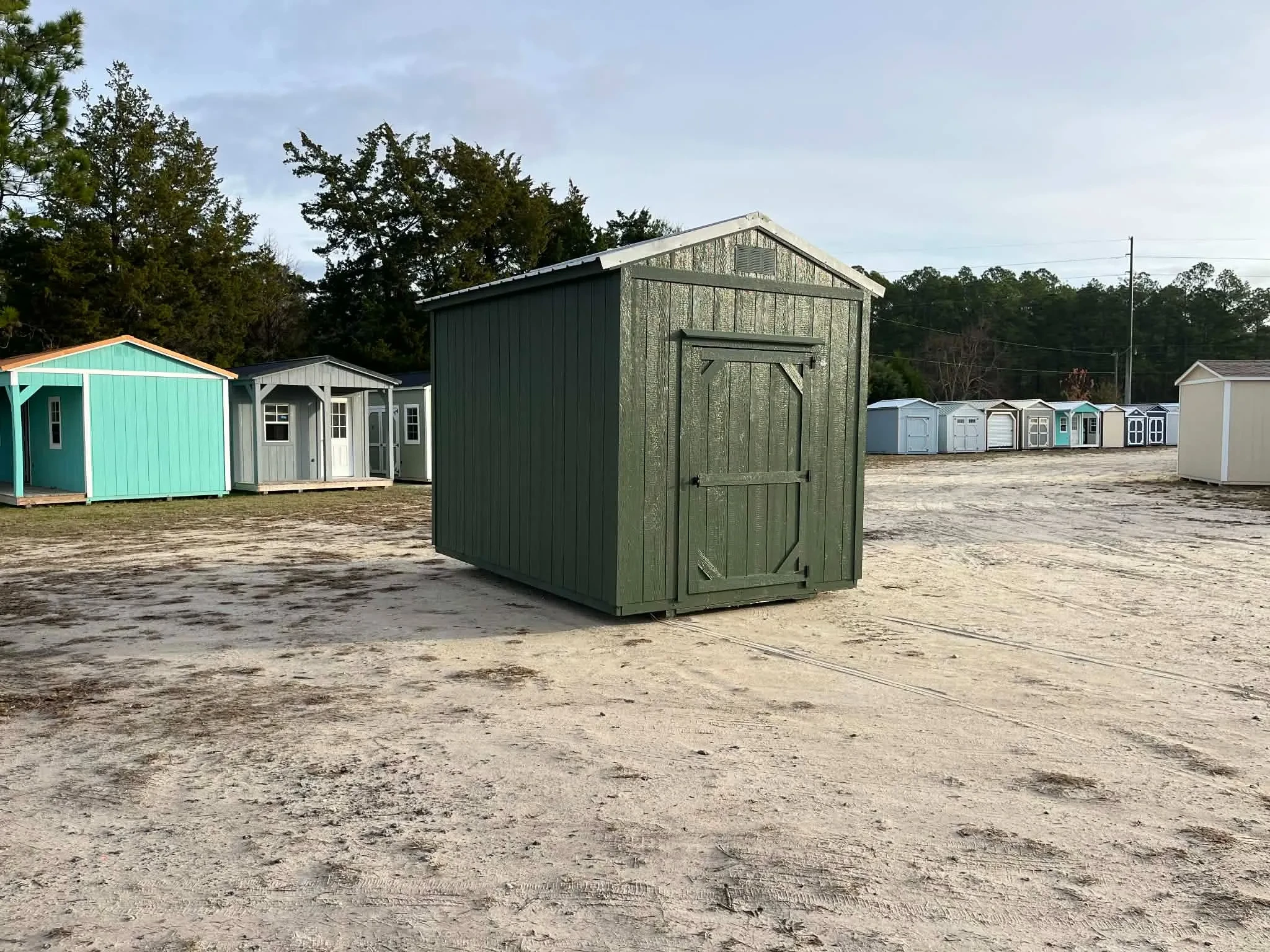 Exterior front view of a green 8x12 garden shed showing the door