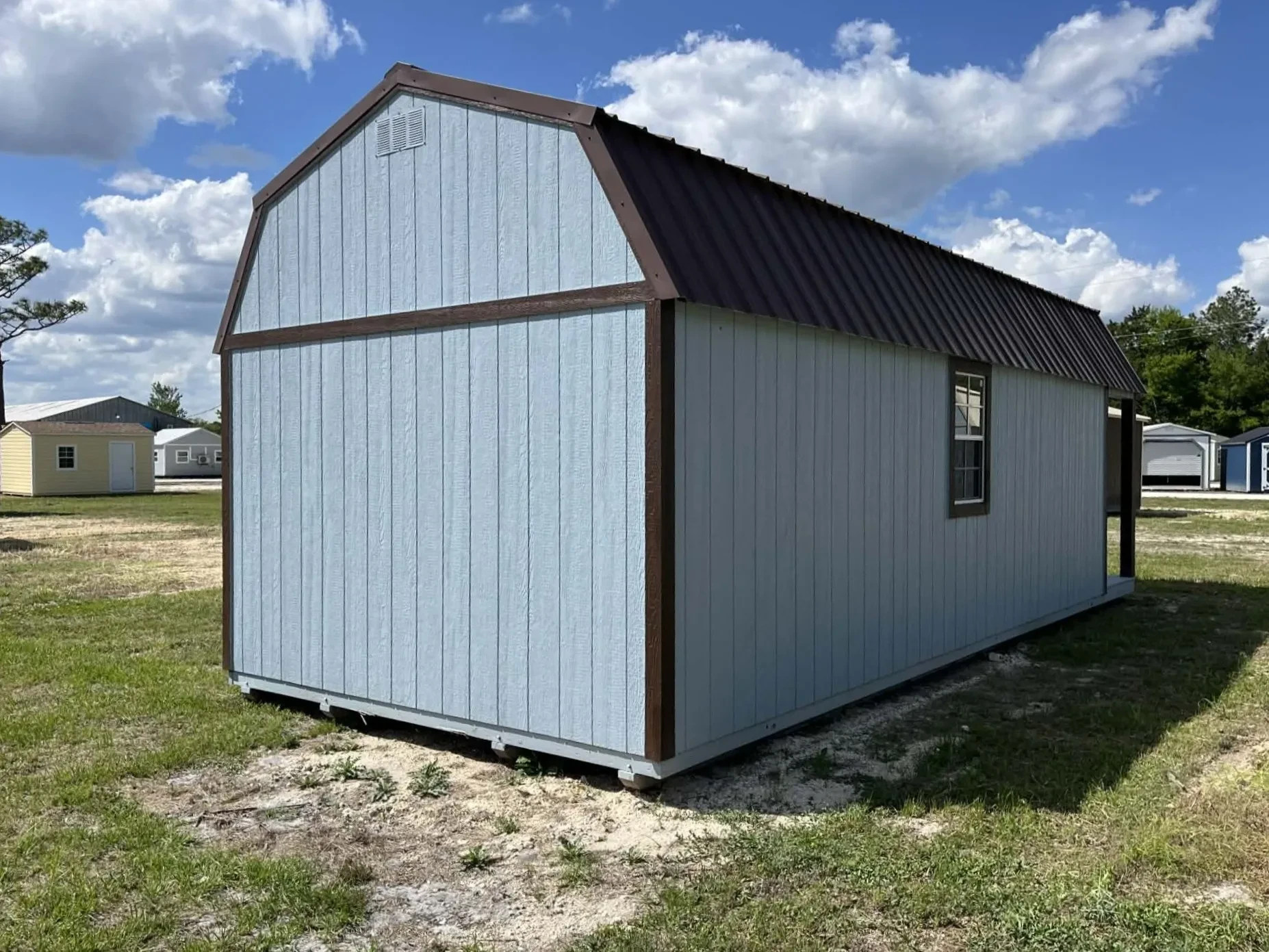 Exterior rear view of a light blue 12x28 lofted barn cabin
