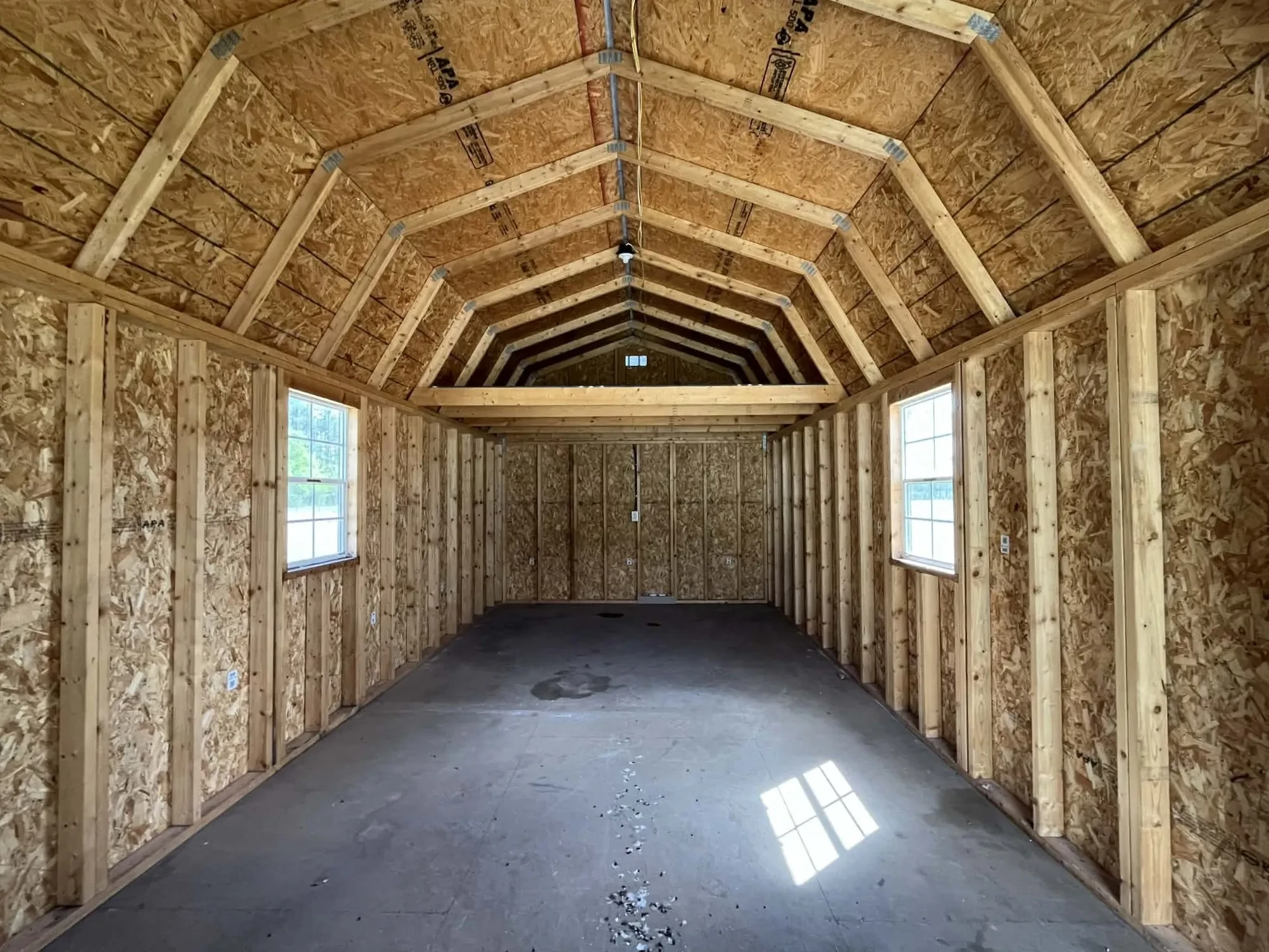 Interior view of a lofted barn cabin showing the loft, walk-in door and windows