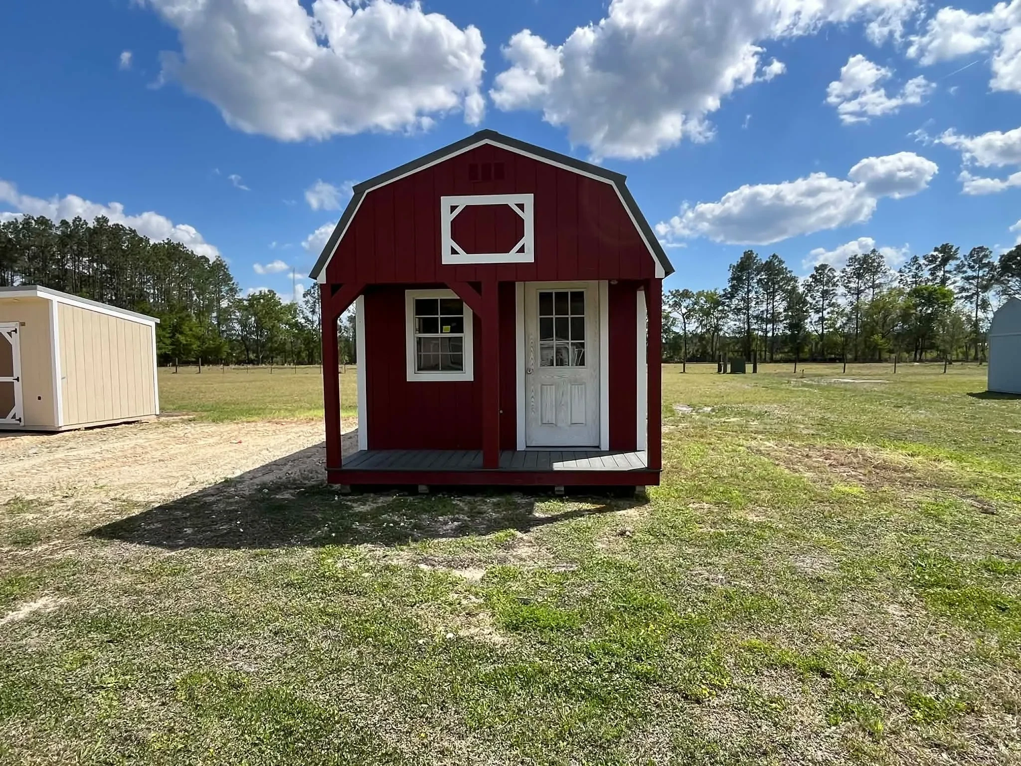 Exterior front view of a 12x24 lofted barn cabin showing the porch, walk-in door and window