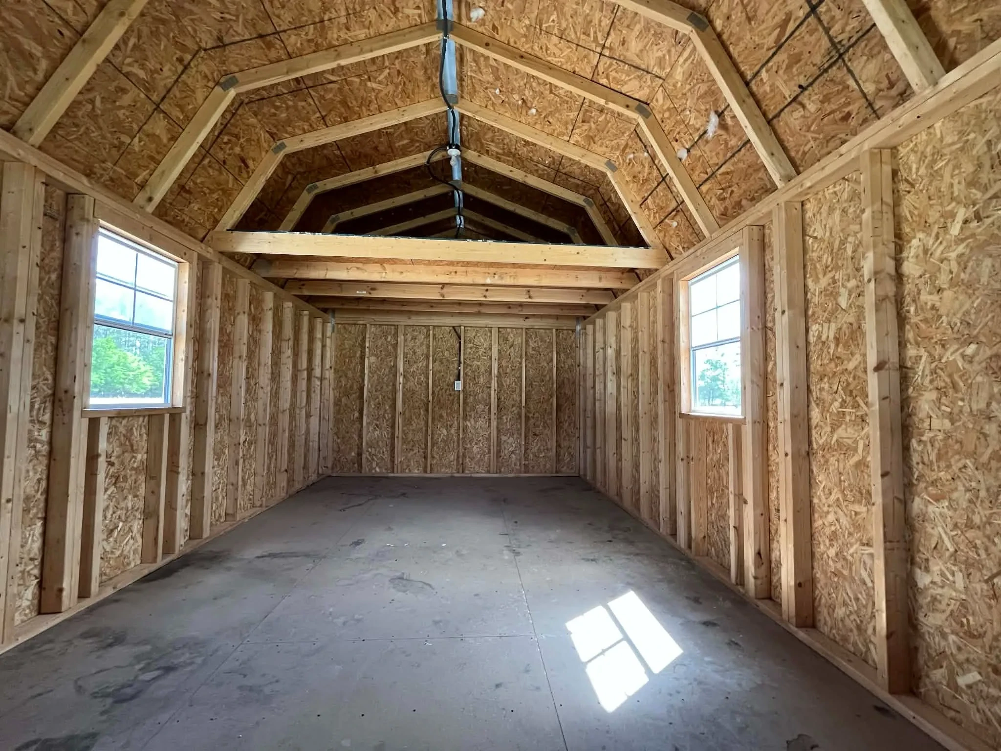 Interior view of a 12x28 lofted barn cabin showing the loft and window.
