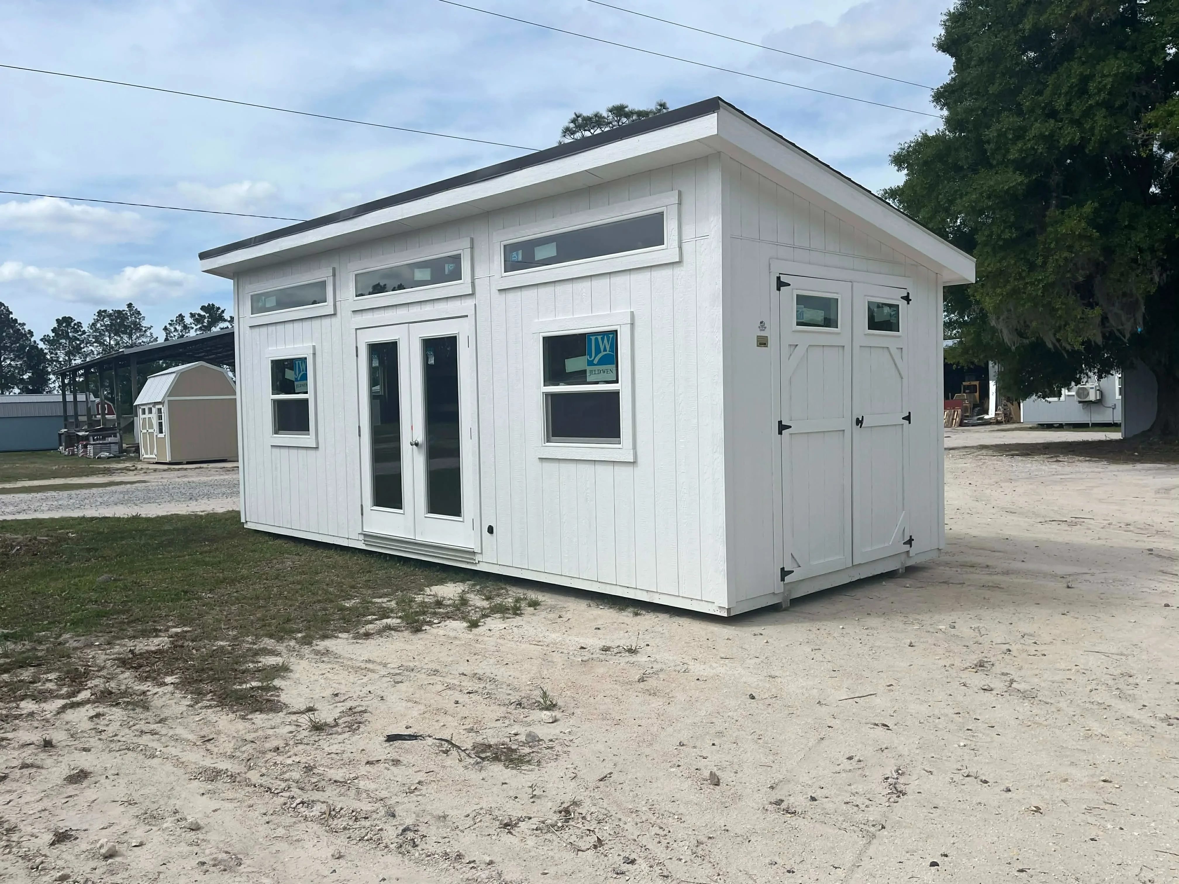 Exterior front right side view of a white 10x24 urban showing the french doors, wood doors and windows