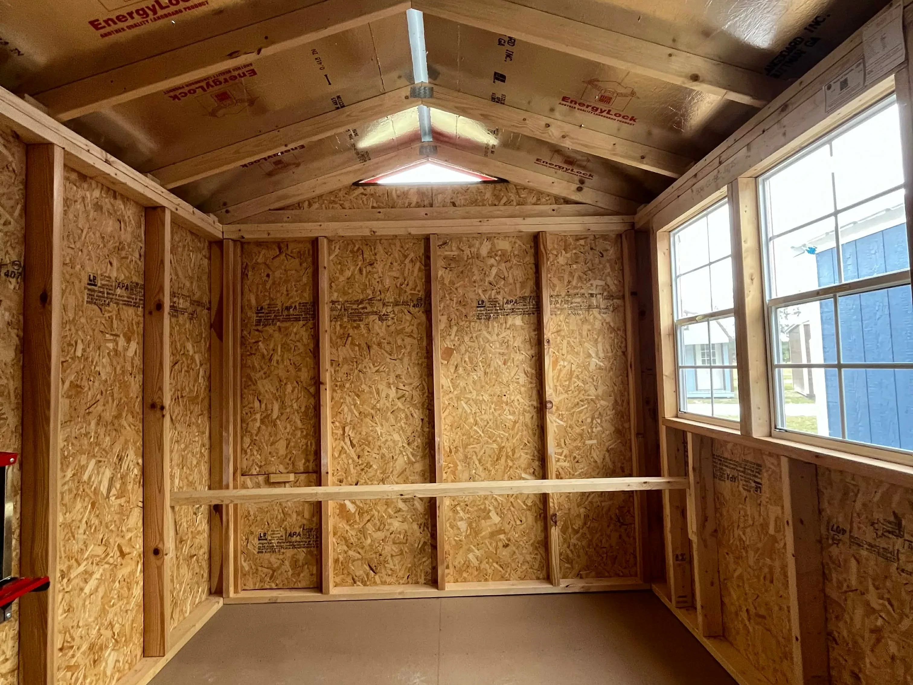 Interior view of an 8x12 chicken coop showing the windows and roost bar