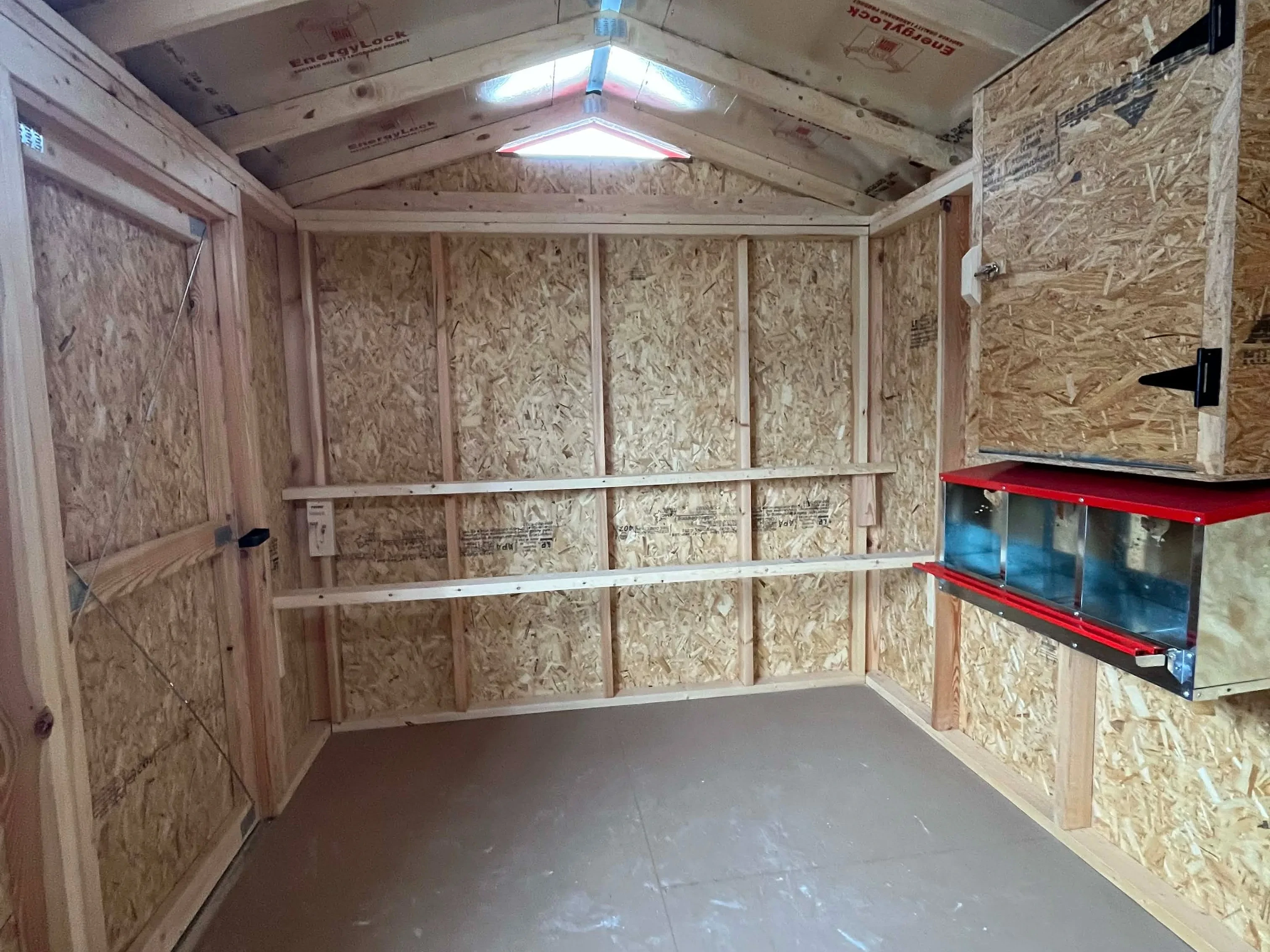 Interior view of an 8x12 chicken coop showing roosting bars and layer boxes