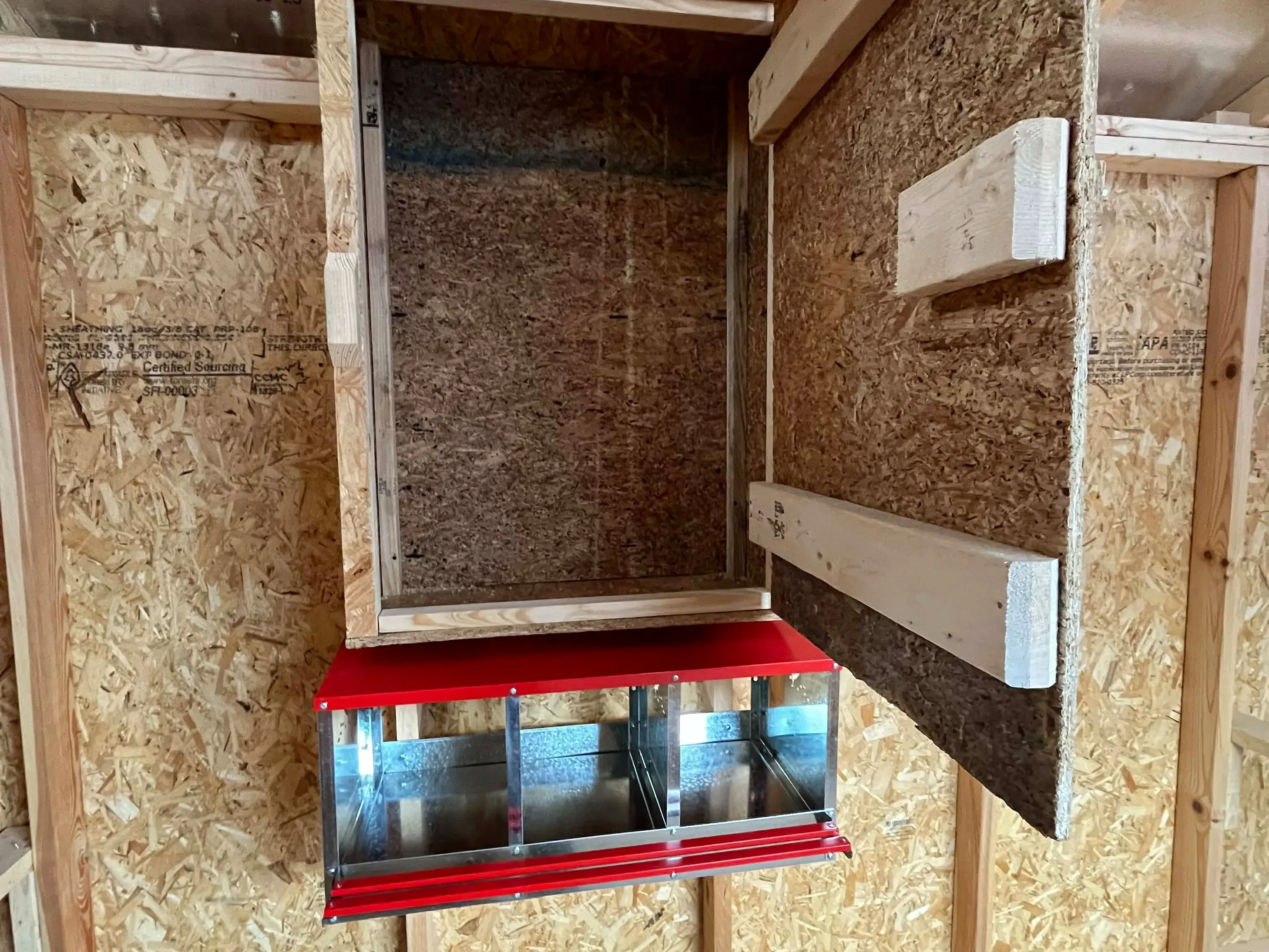 Interior view of an 8x12 chicken coop showing the layer boxes and storage