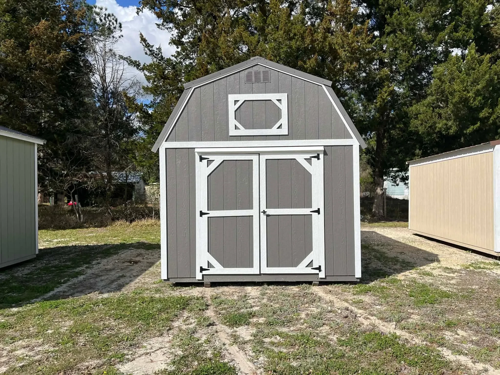 Exterior front view of a dark grey 10x16 lofted barn showing the double wood doors
