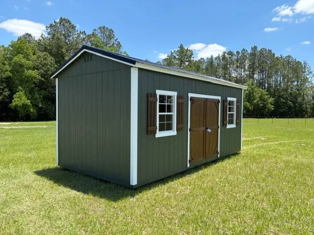 Exterior front left view of a green 10x20 side garden shed showing the doors, windows and shutters