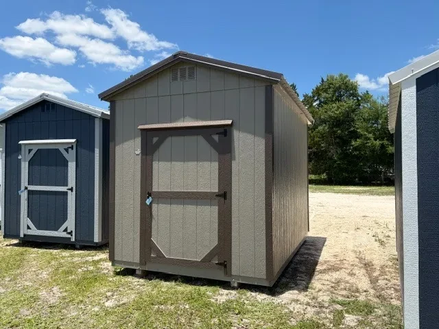 Exterior front right view of a clay 8x12 garden shed showing a wood door