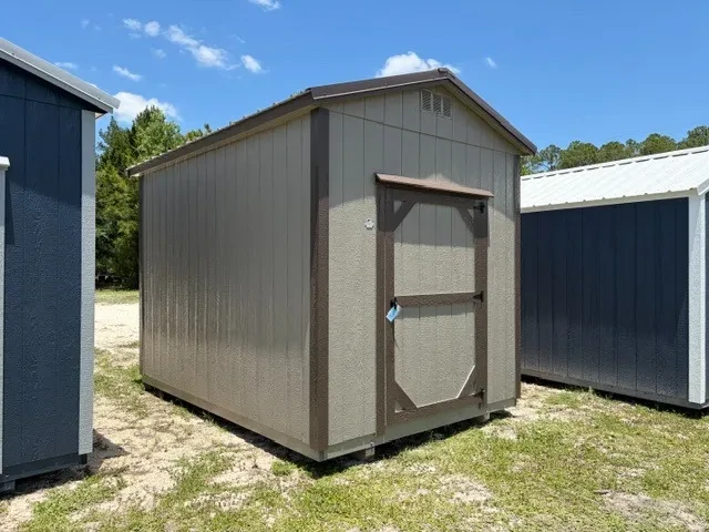 Exterior front left view of a clay garden shed showing a wood door