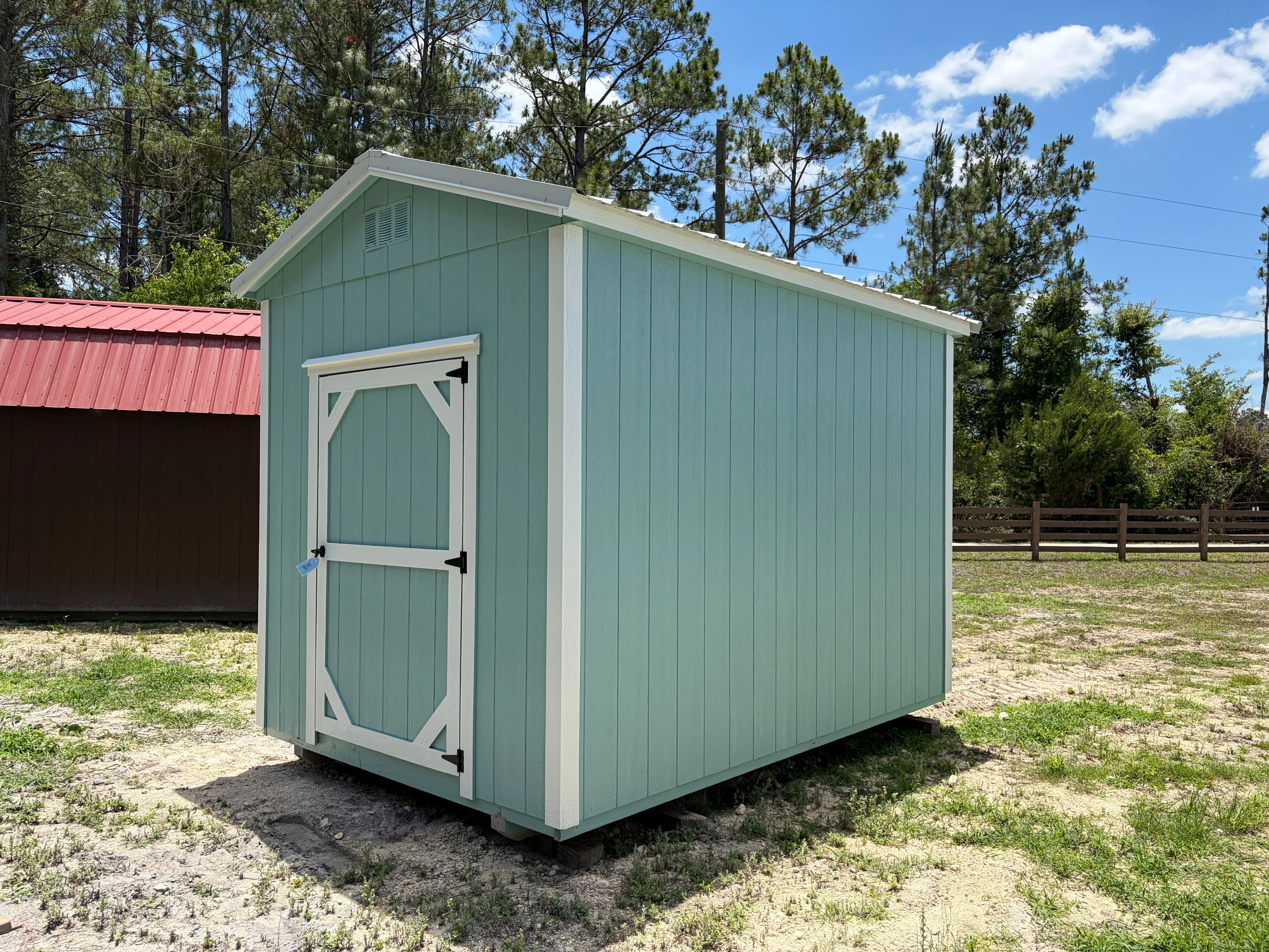 Exterior front right view of a aqua 8x12 garden shed showing the wood door