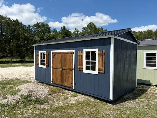 Exterior front right view of a dark blue 10x20 side garden shed showing the wood door, windows and shutters