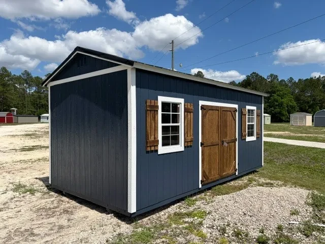 Exterior front left view of a dark blue 10x20 side garden shed showing the wood door, windows and shutters