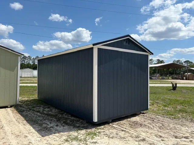 Exterior front right view of a dark blue side garden shed showing the wood door, windows and shutters