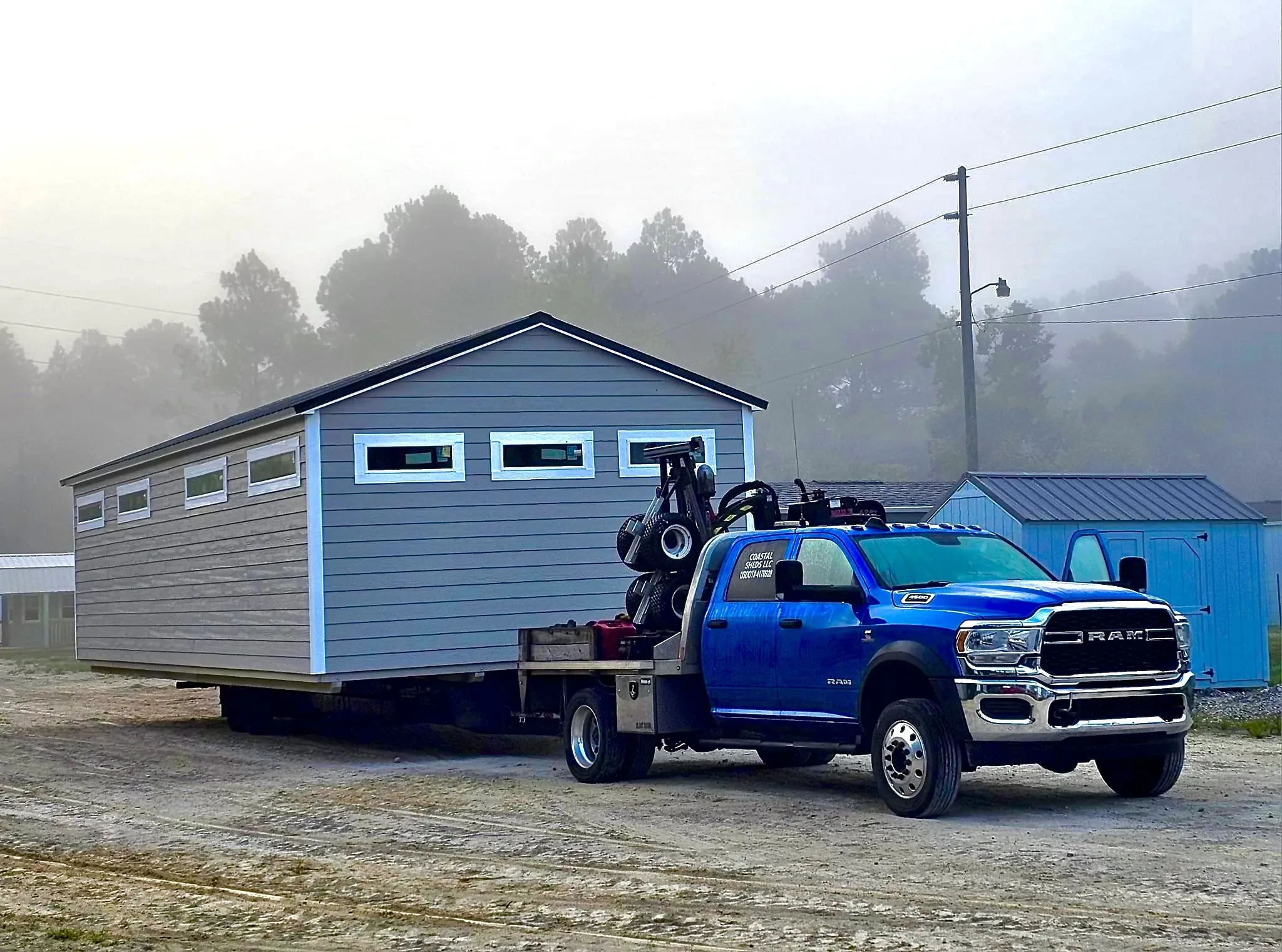 Truck and trailer loaded with a shed ready to be moved