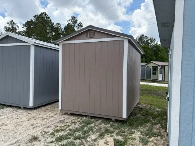 Back view of an 8x12 side garden shed with painted taupe siding and white trim and roof