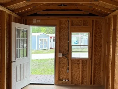 Interior of 10x20 cabin showing inside of entry door, window, and one light socket