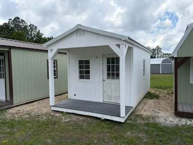 Outside of a 10x20 cabin showing front porch, entry door, and two windows