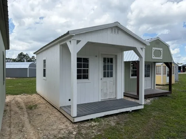 Outside of a 10x20 cabin showing front porch, entry door, and two windows