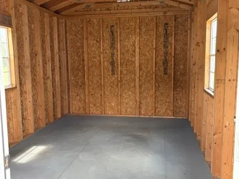Inside view of 10x20 cabin showing two windows and one light socket