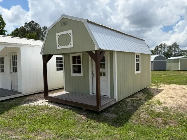 Outside of a 10x20 lofted barn cabin showing front porch, entry door, and two windows