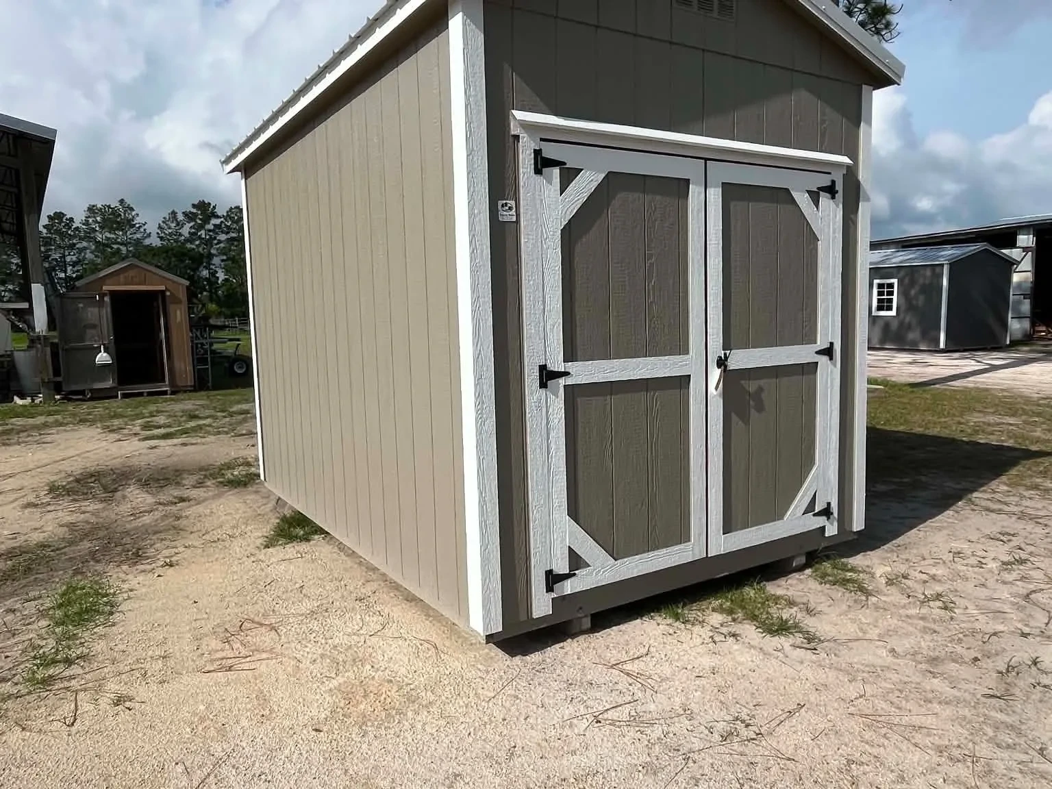 Exterior front left view of a clay color 8x12 garden shed with doors