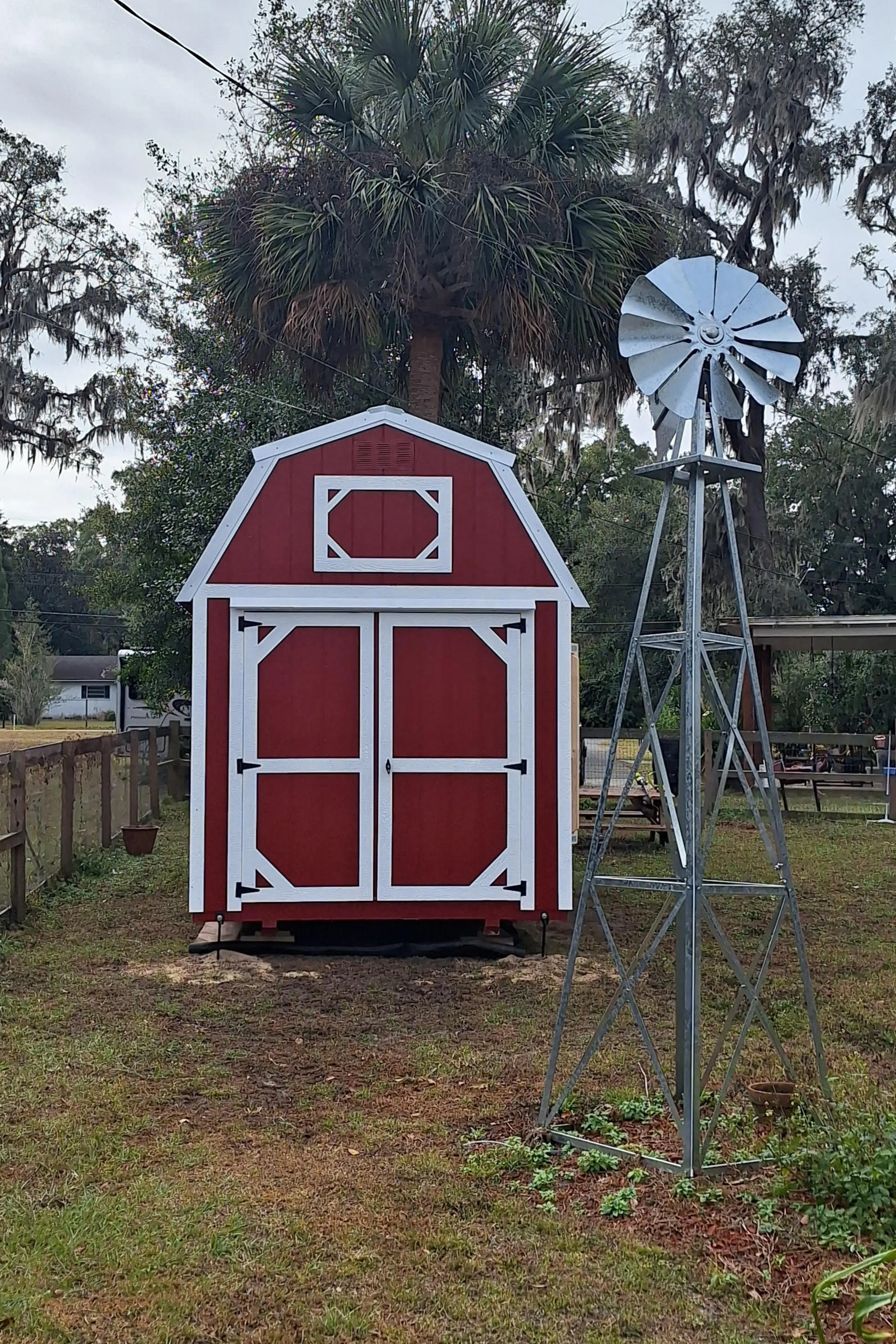 Little red lofted barn shed by a windmill