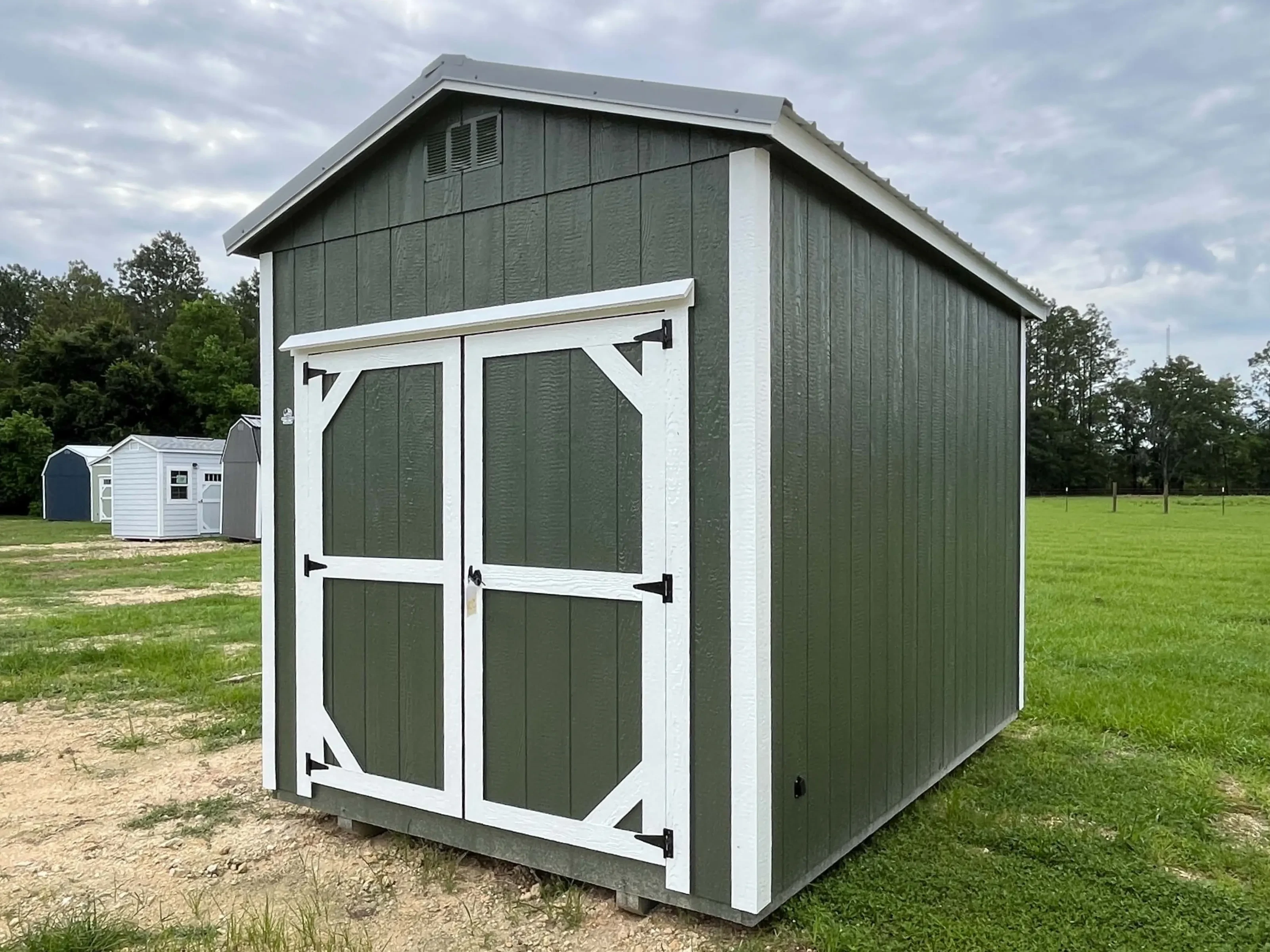 Exterior front right view of a green 8x12 garden shed with wood door