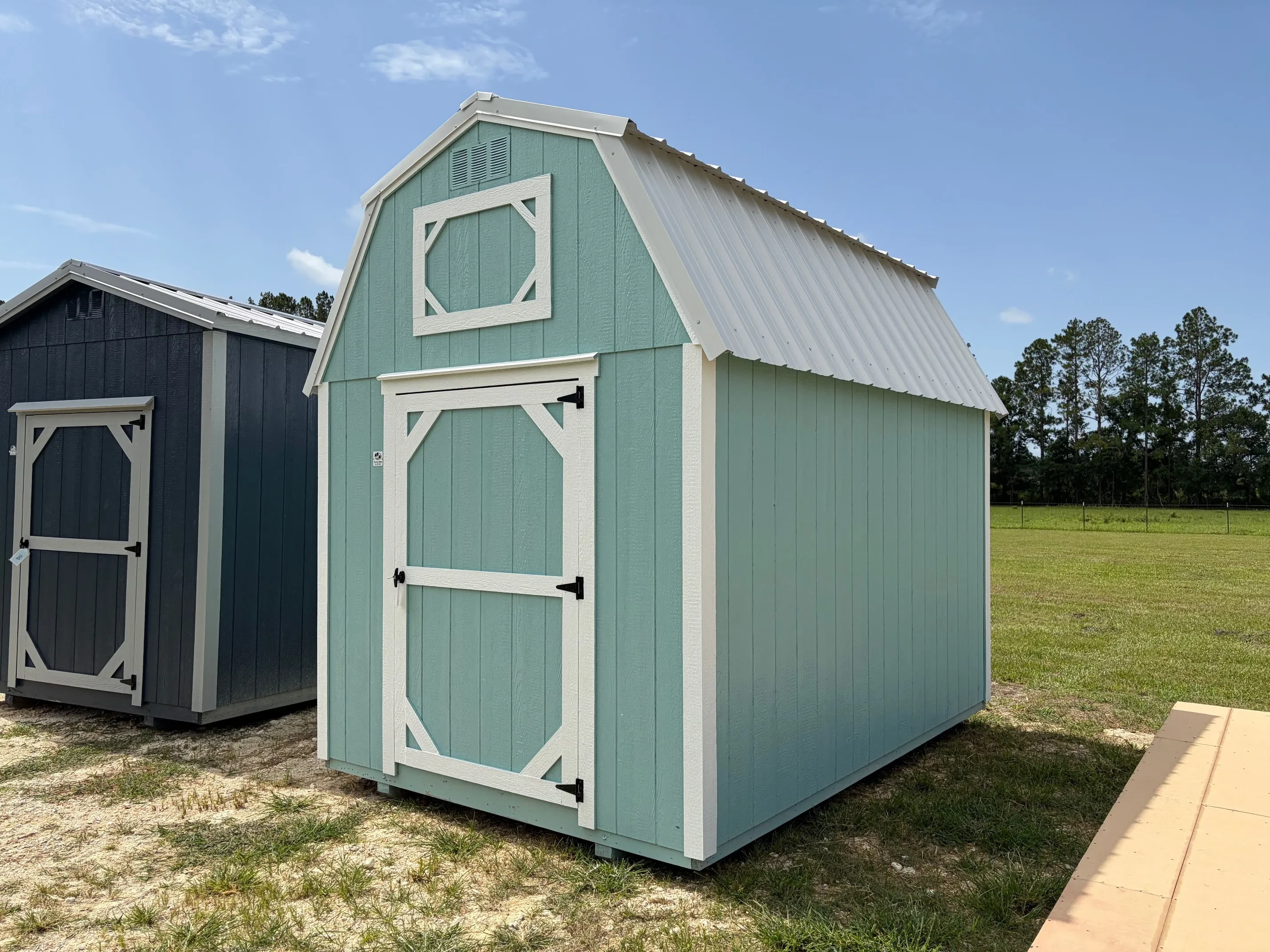 Exterior front right view of aqua verde 8x12 lofted barn with a wood door