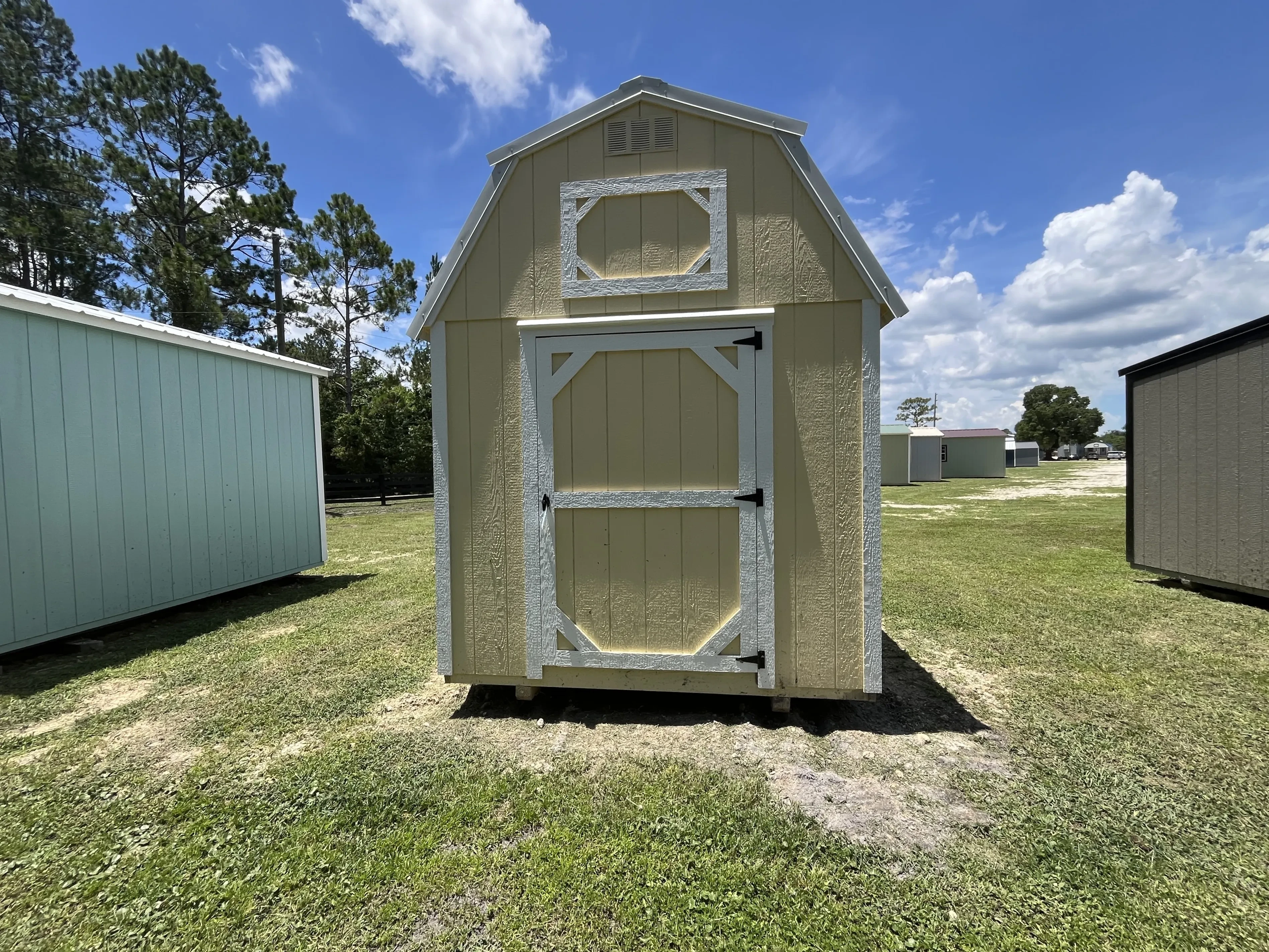Exterior Front view of an 8x12 yellow lofted Barn showing the door