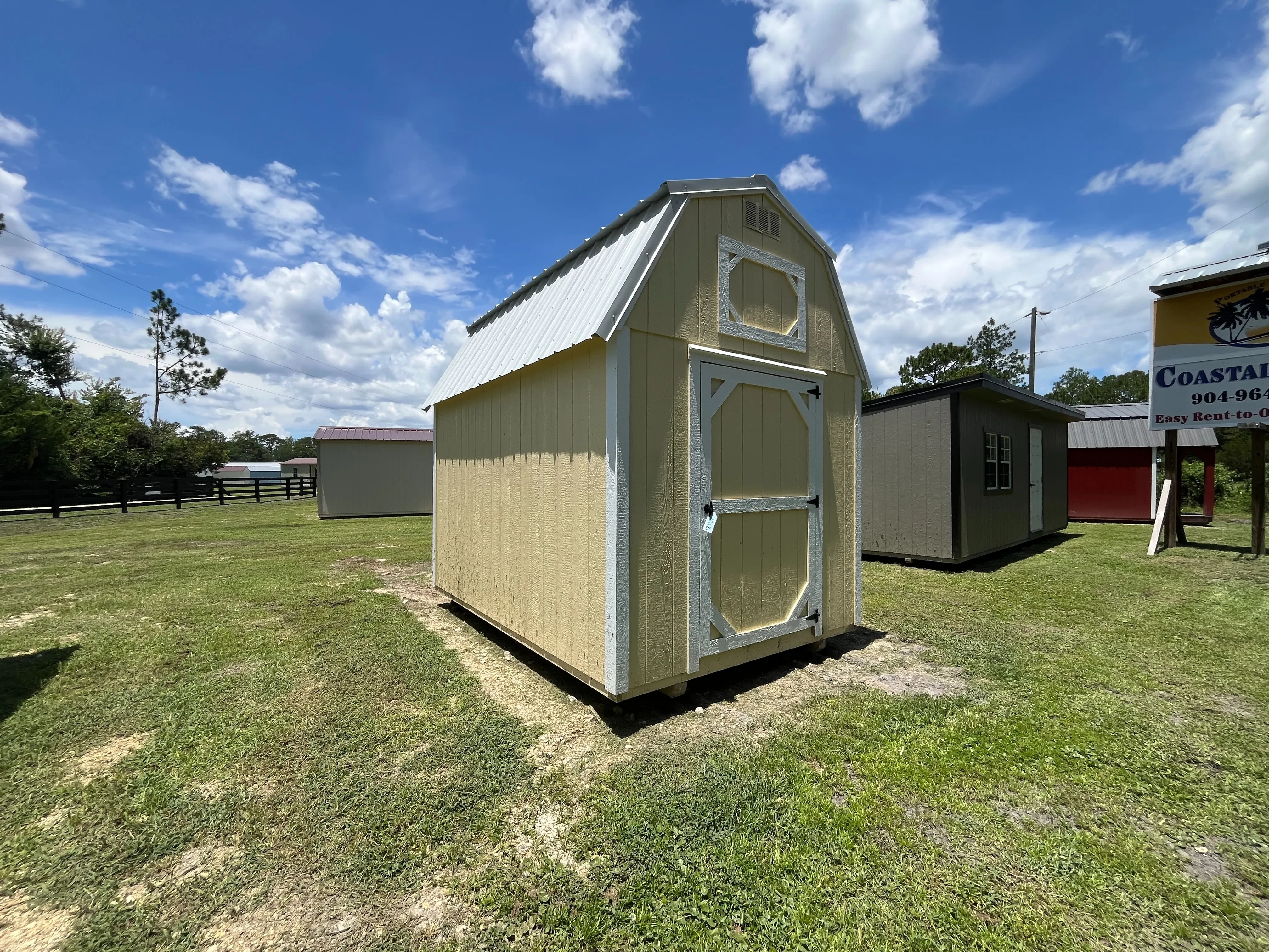 Exterior Front left view of an 8x12 yellow lofted Barn showing the door