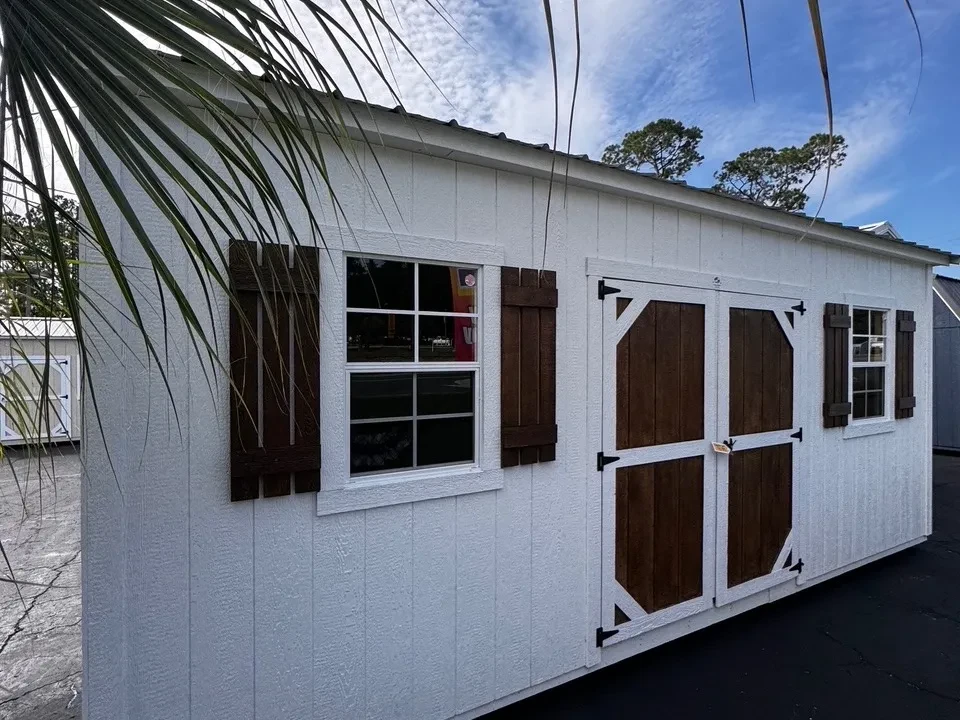 Exterior front left view of a white 10x20 side garden shed showing the wood door