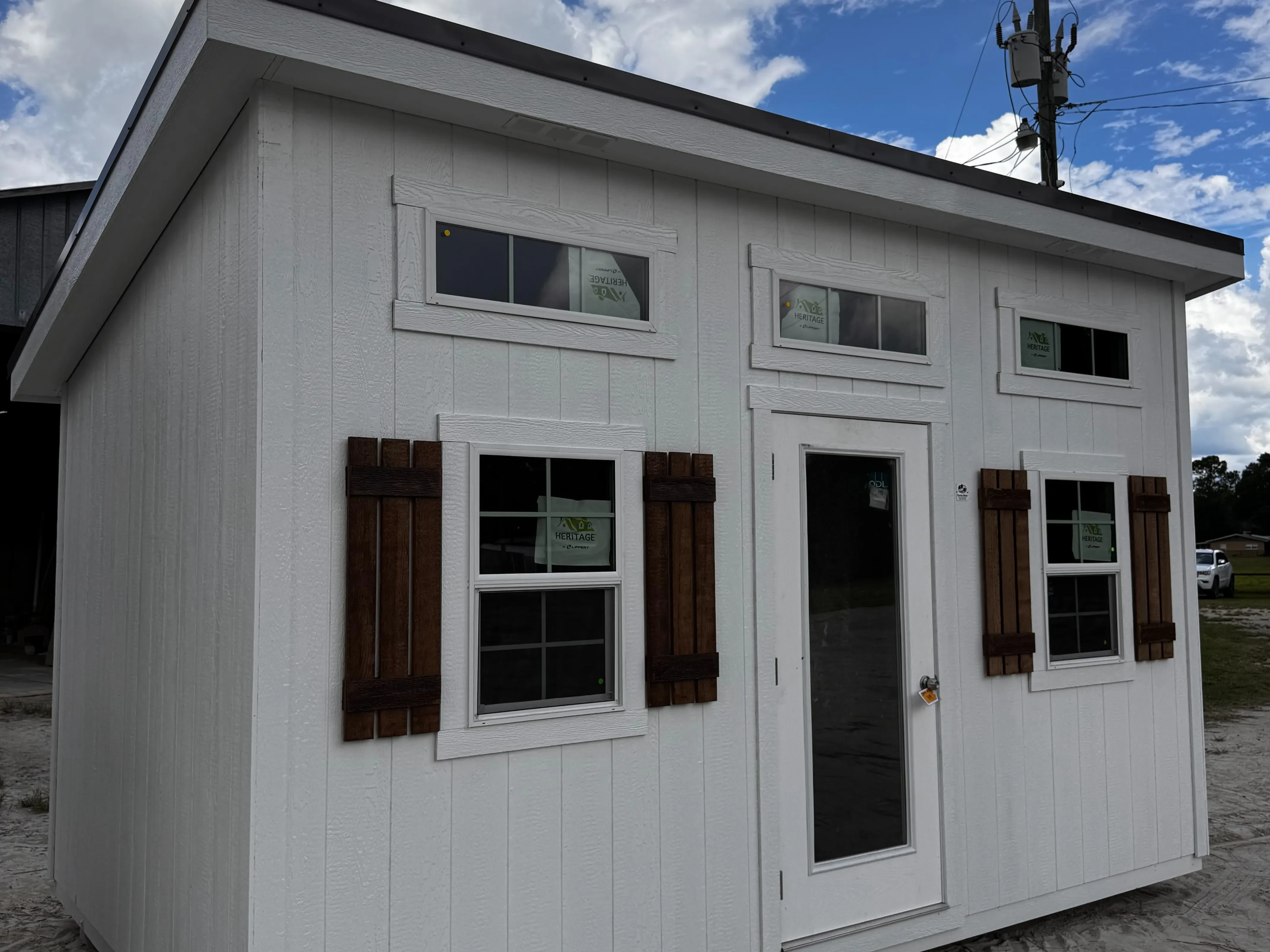 Exterior of a 10x16 white in color Urban showing the walk-in door and windows