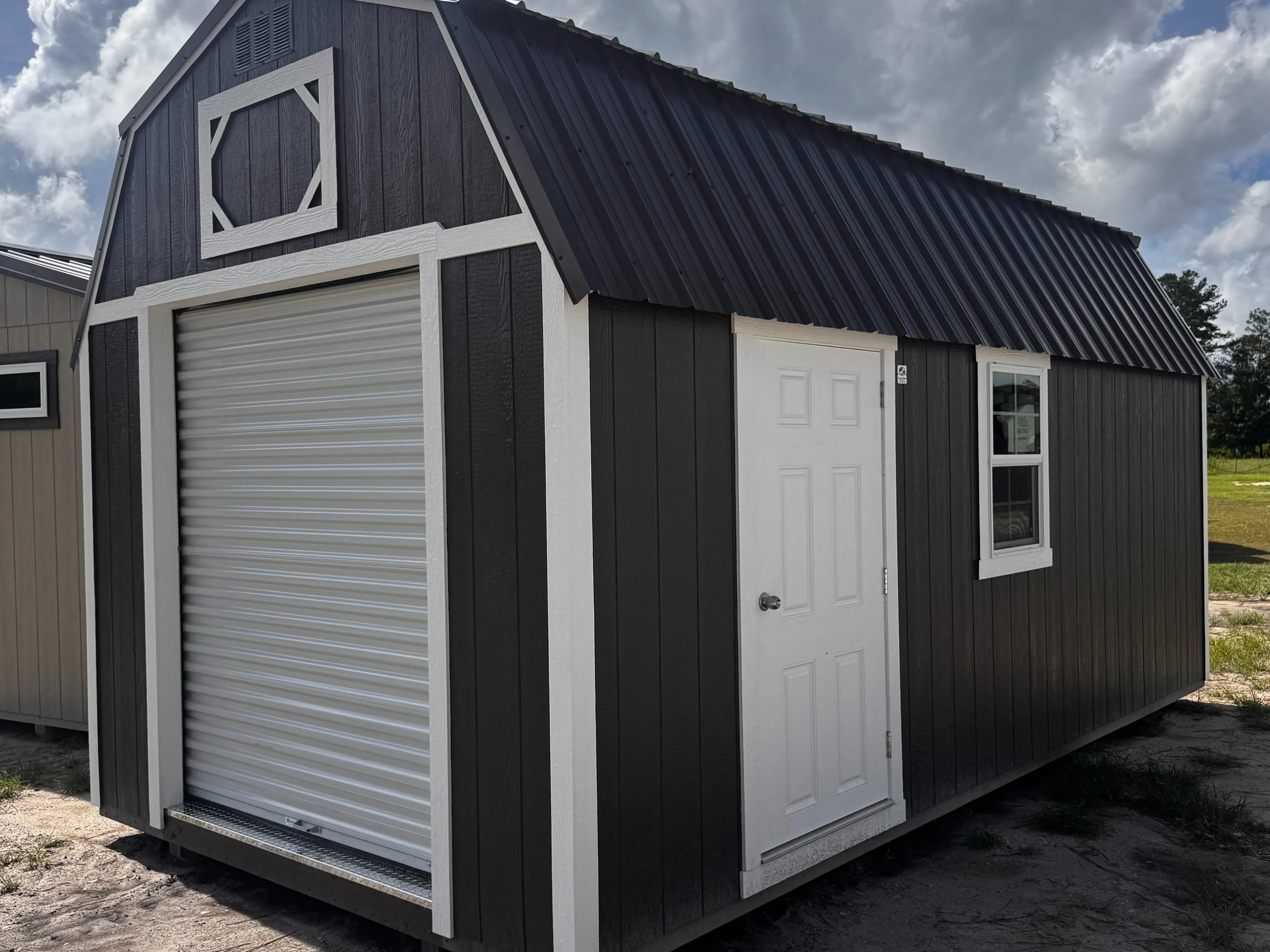 Exterior of a Bronze 10x20 Lofted Workshop showing a garage door in the end and a walk-in door and window on the side