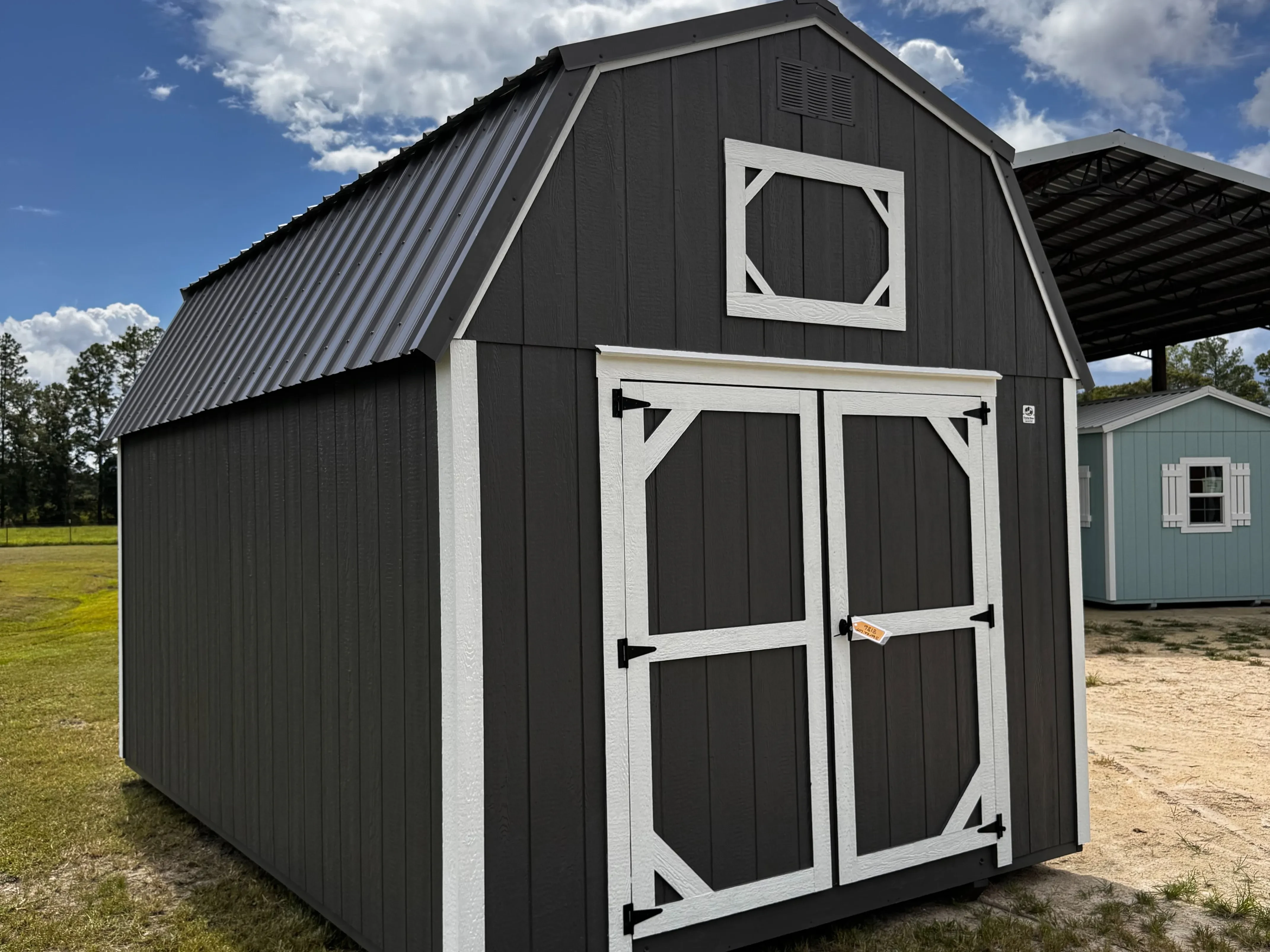 1Exterior front view of a Charcoal 10x16 lofted barn with a wood door