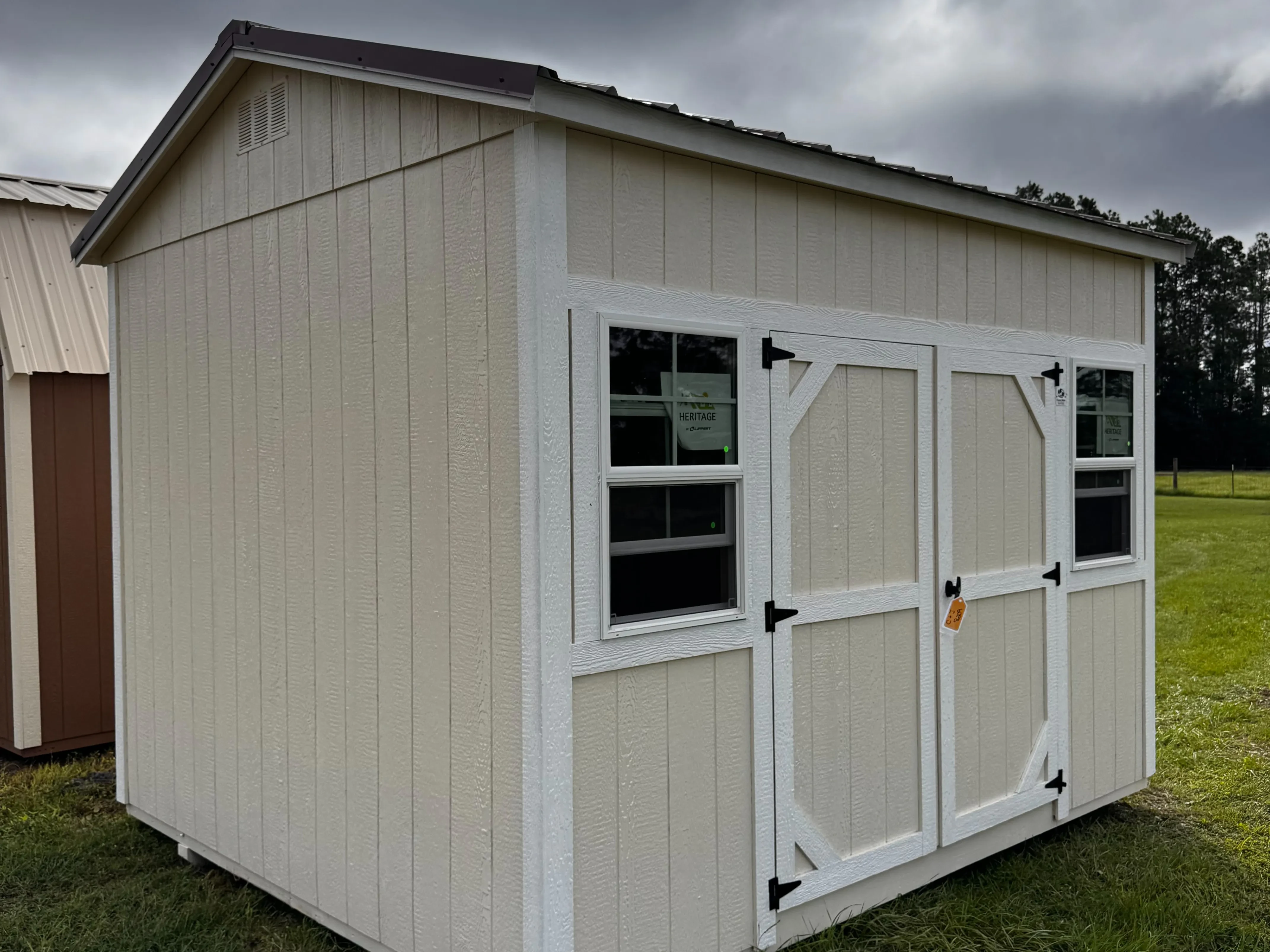 Exterior of a navajo white 10x12 side garden shed with double wood doors and windows